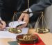 golden-justice-scale-book-stack-front-lawyer-signing-document